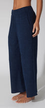 Navy blue textured pants worn by a person on a white background