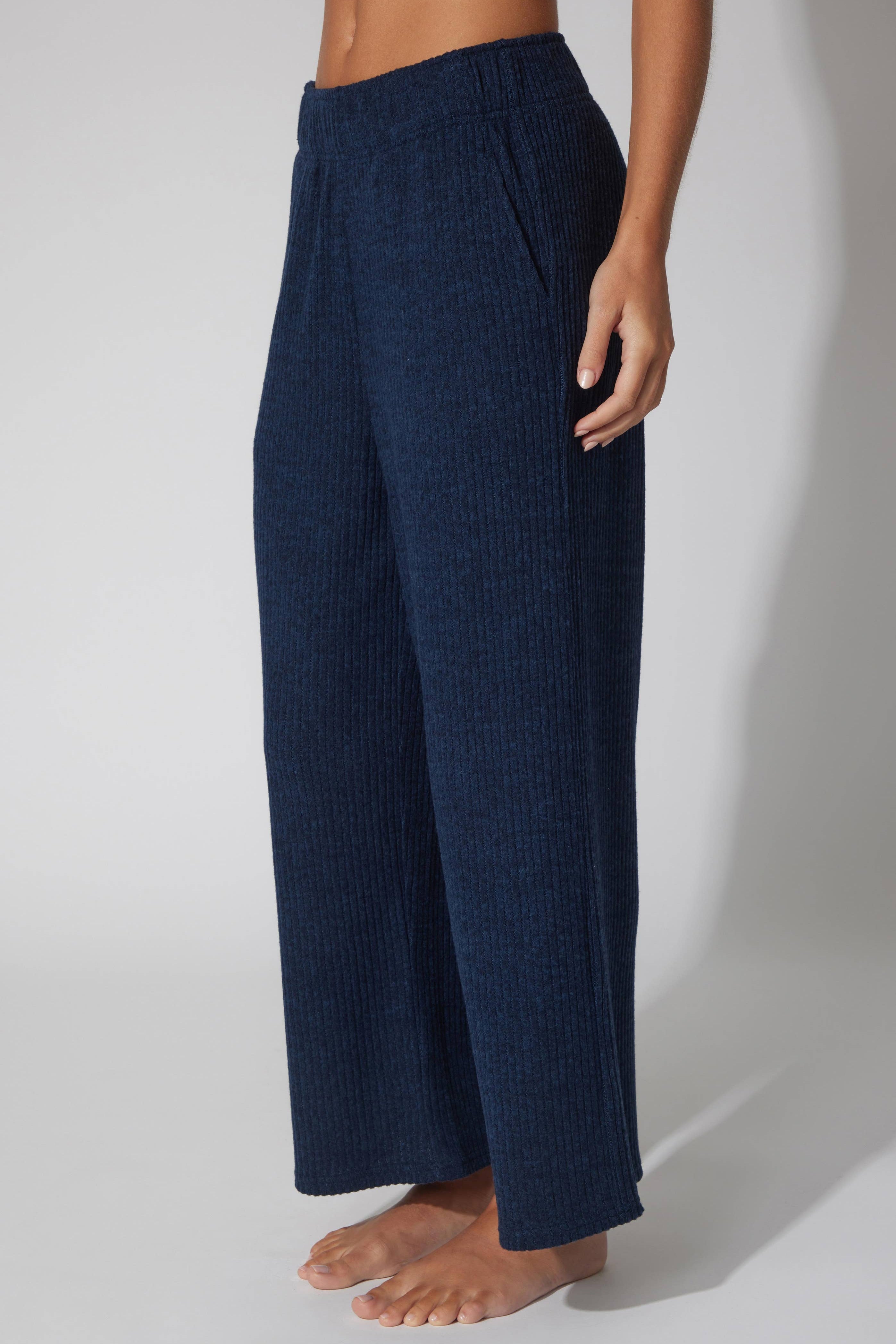 Navy blue textured pants worn by a person on a white background