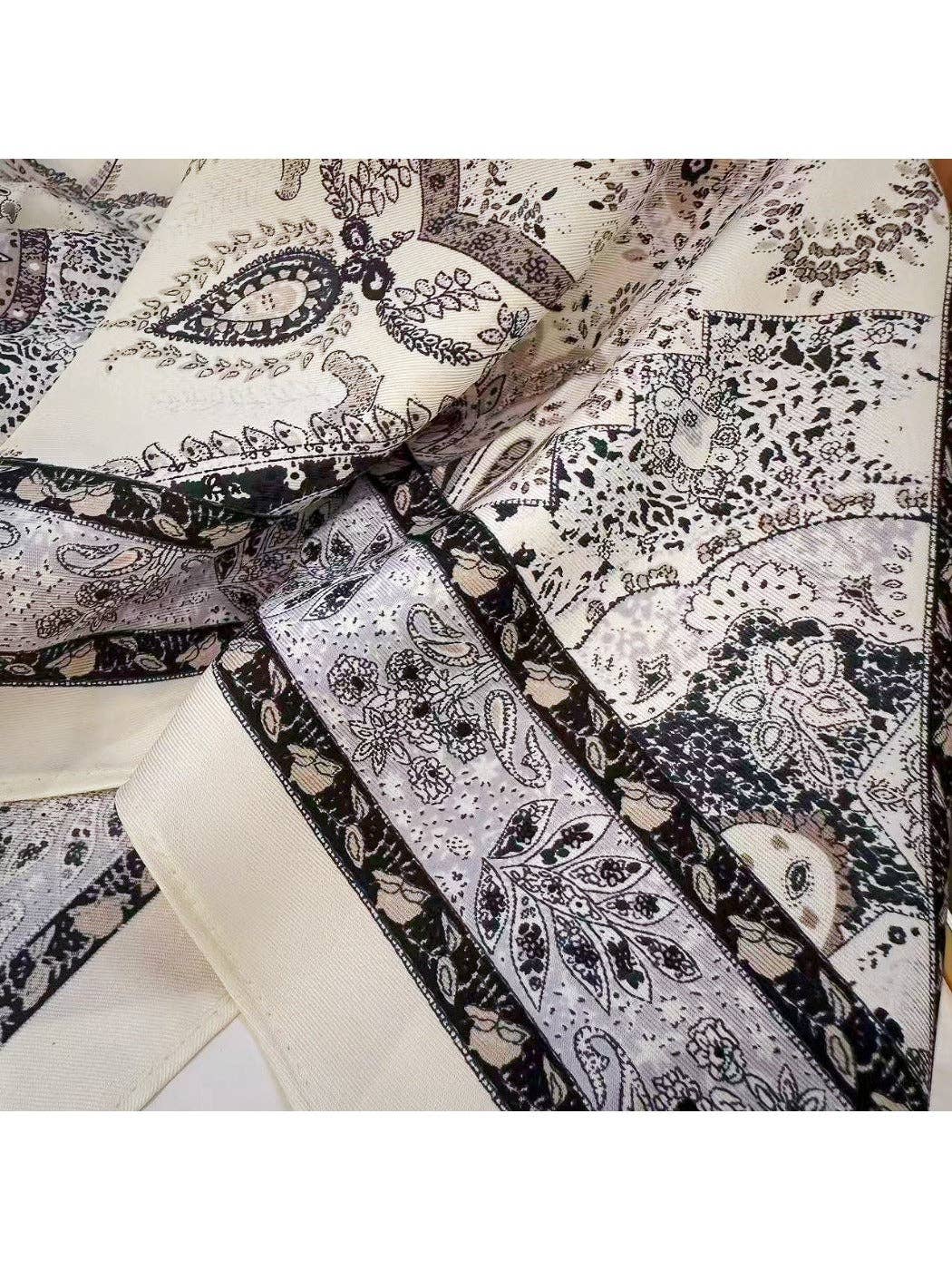 Muted grey triangle bandana scarf close-up of dark paisley and swirl print on cream fabric