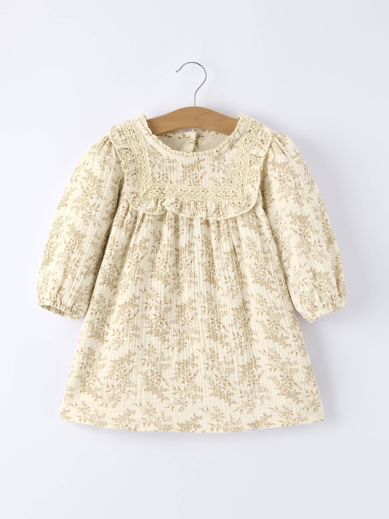 Beige lace dress on a hanger against a white background