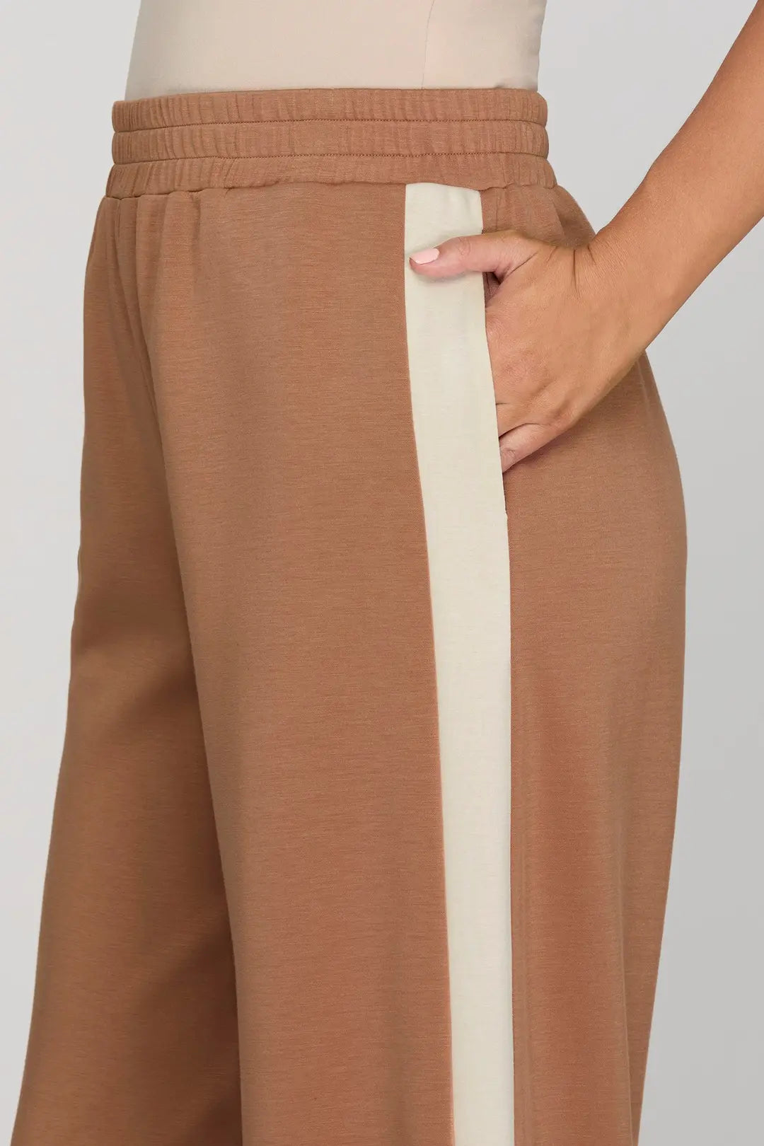 Brown pants with a white stripe on a plain background