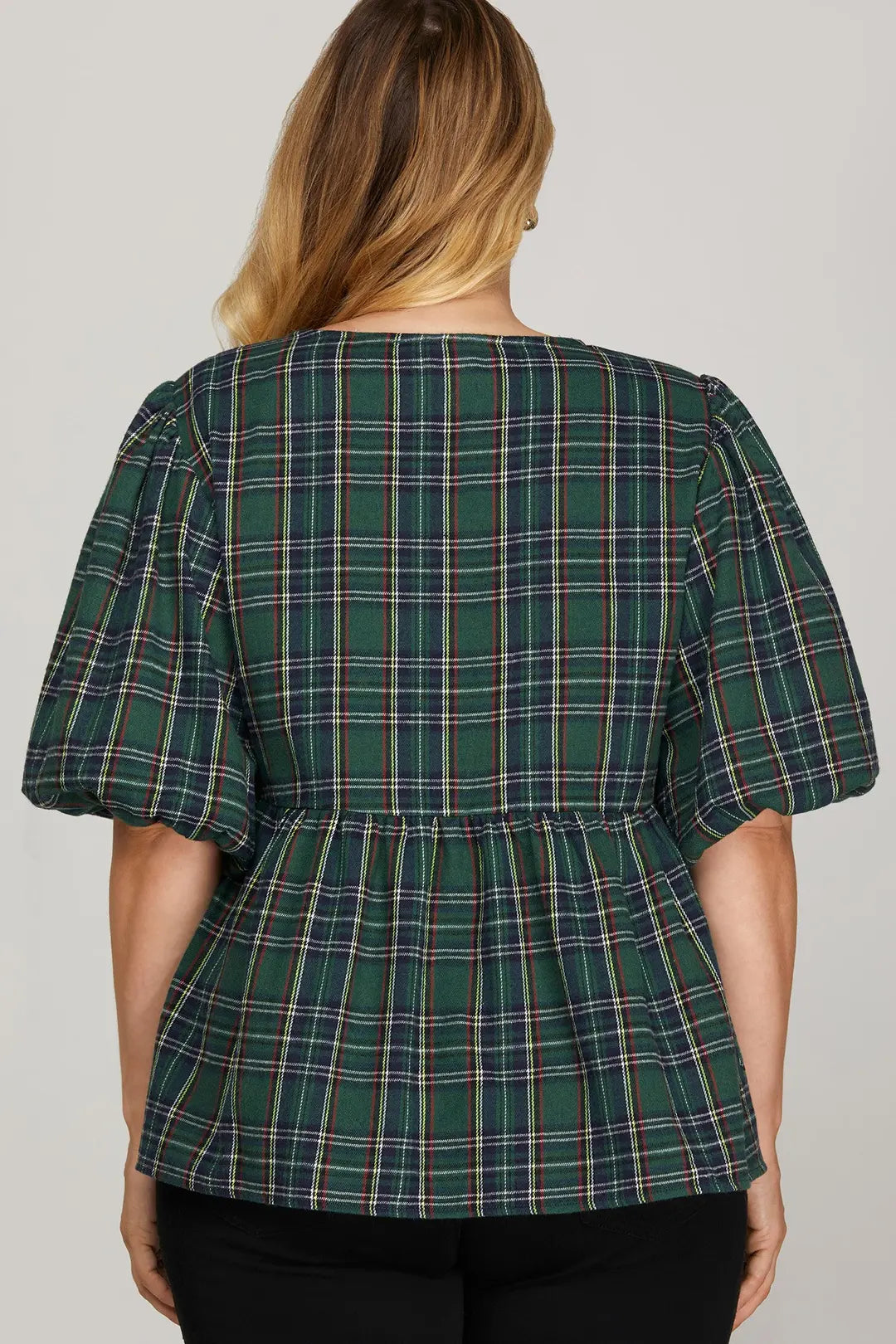Green plaid blouse worn by a person on a plain background