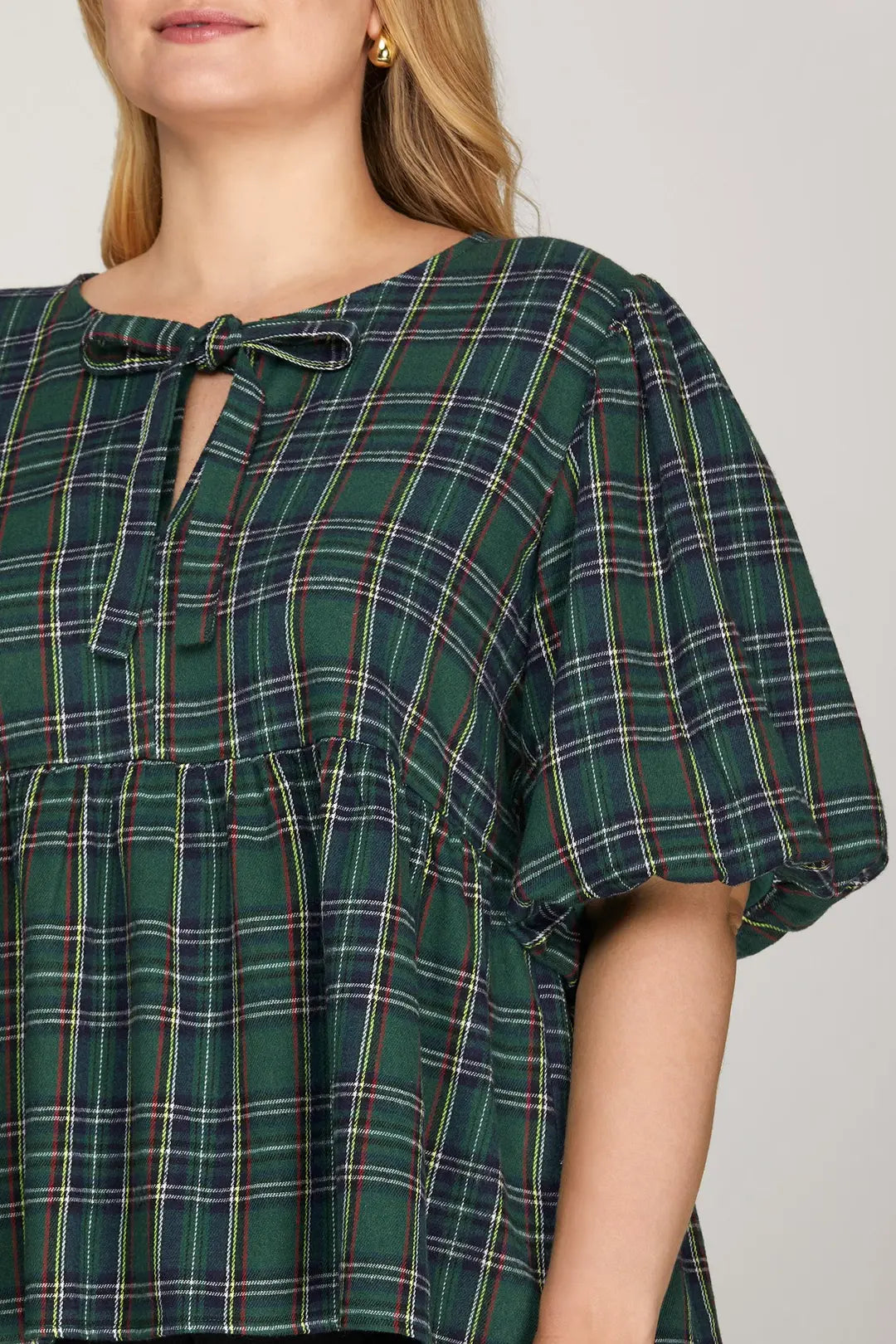 Green plaid dress with a close-up of the neckline on a plain background