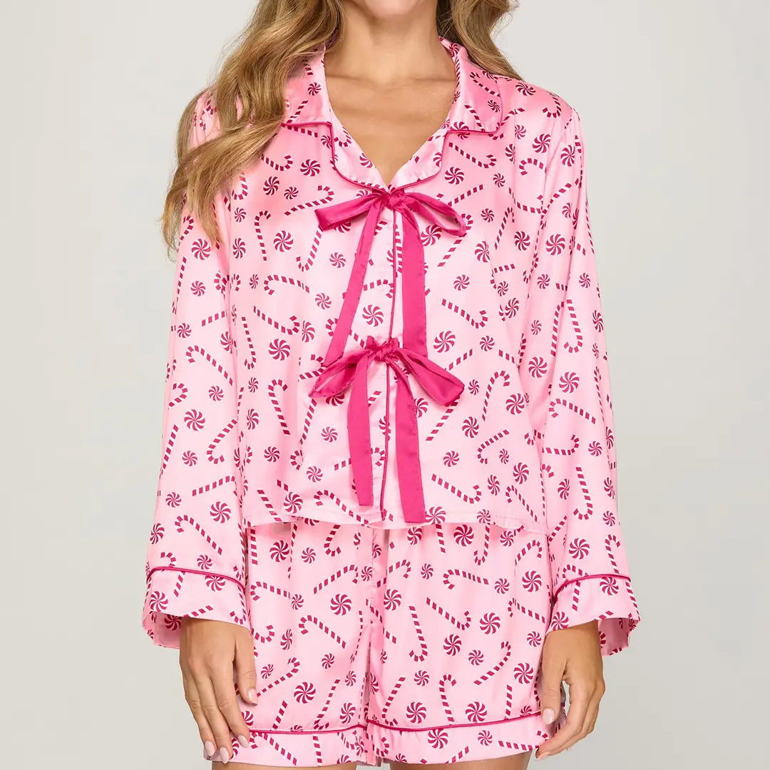 Women wearing long sleeve pink pajama top that ties in the front with matching shorts with dark pink candy cane and peppermint design