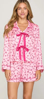 Women wearing long sleeve pink pajama top that ties in the front with matching shorts with dark pink candy cane and peppermint design