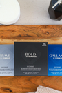 Three boxes of Sporelle homme body wash on a wooden surface
