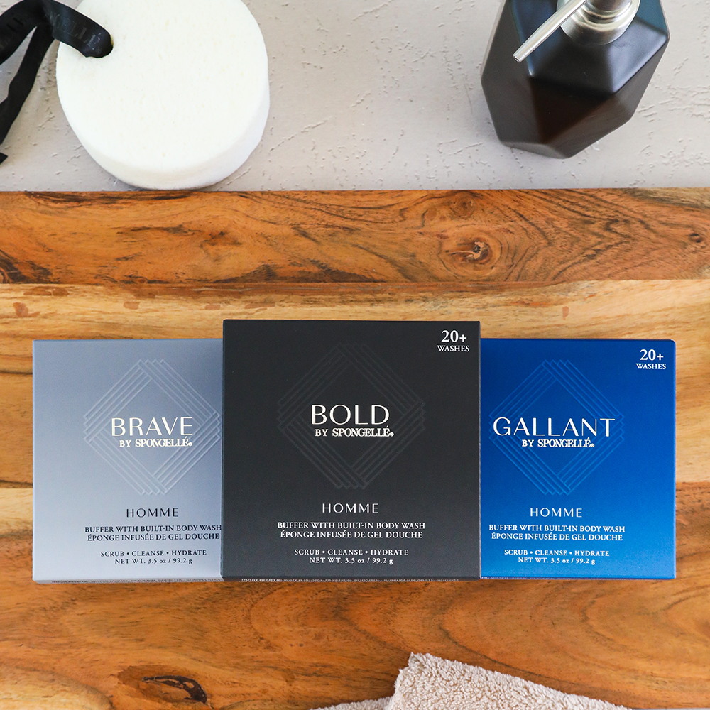 Three boxes of Sporelle homme body wash on a wooden surface