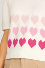 Close-up of a sweater with pink heart pattern on a white background