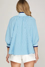 Woman wearing a blue and white striped shirt with a plain background