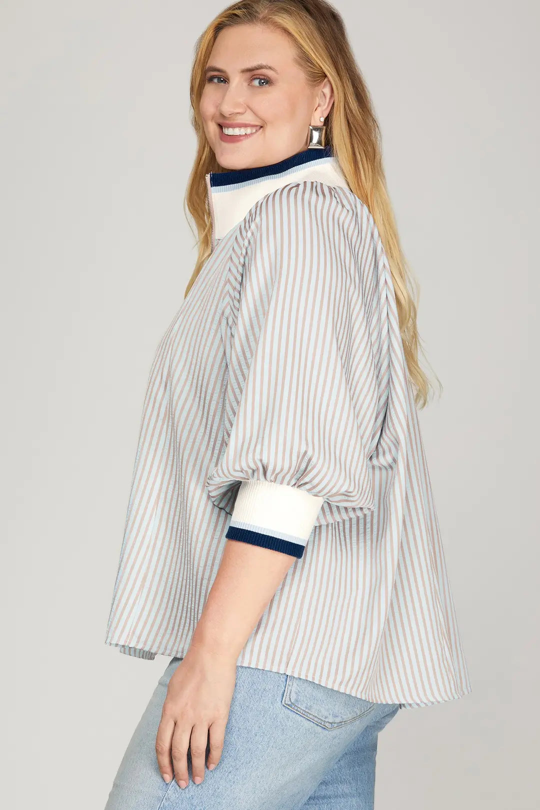 Woman wearing a striped blouse with a plain background