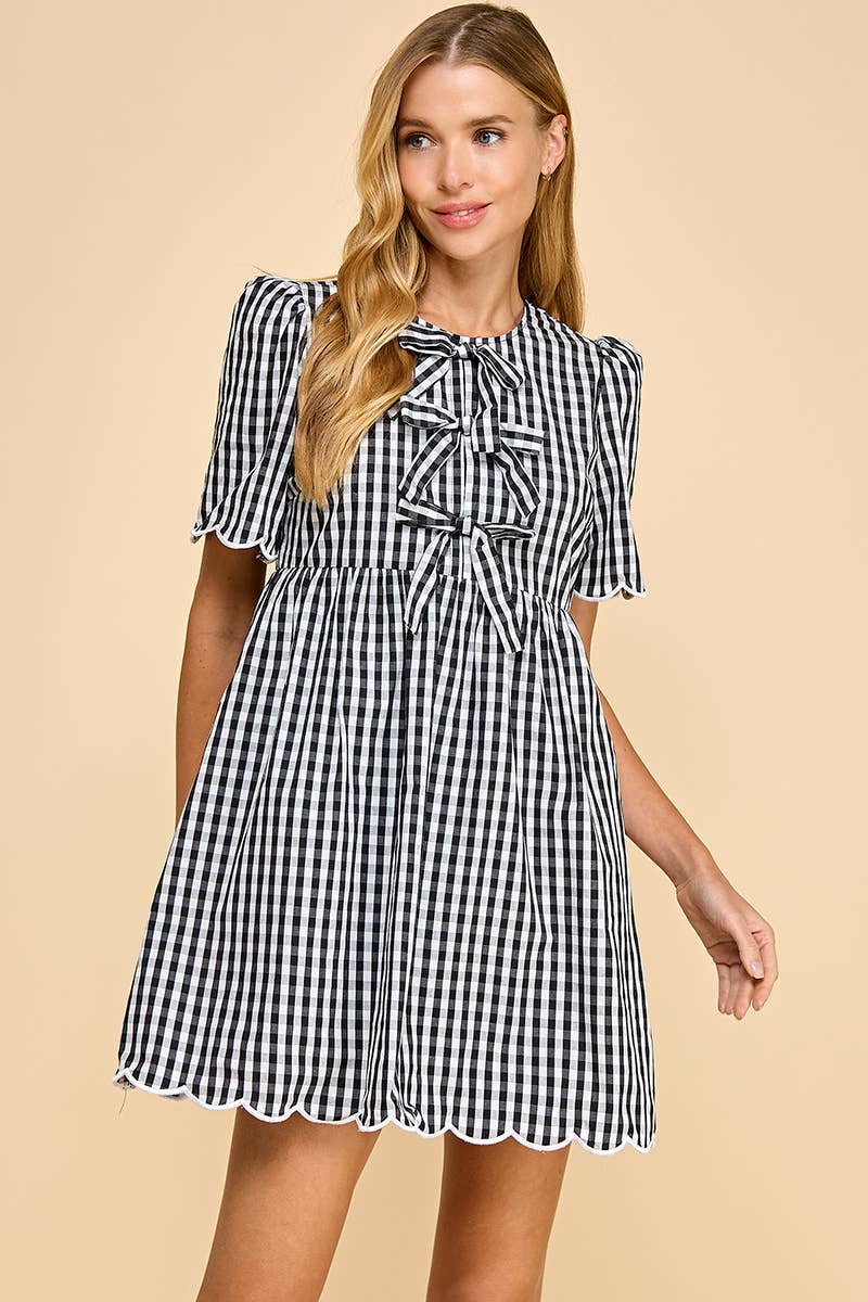Woman wearing a black and white checkered dress on a beige background