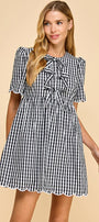 Woman wearing a black and white checkered dress on a beige background