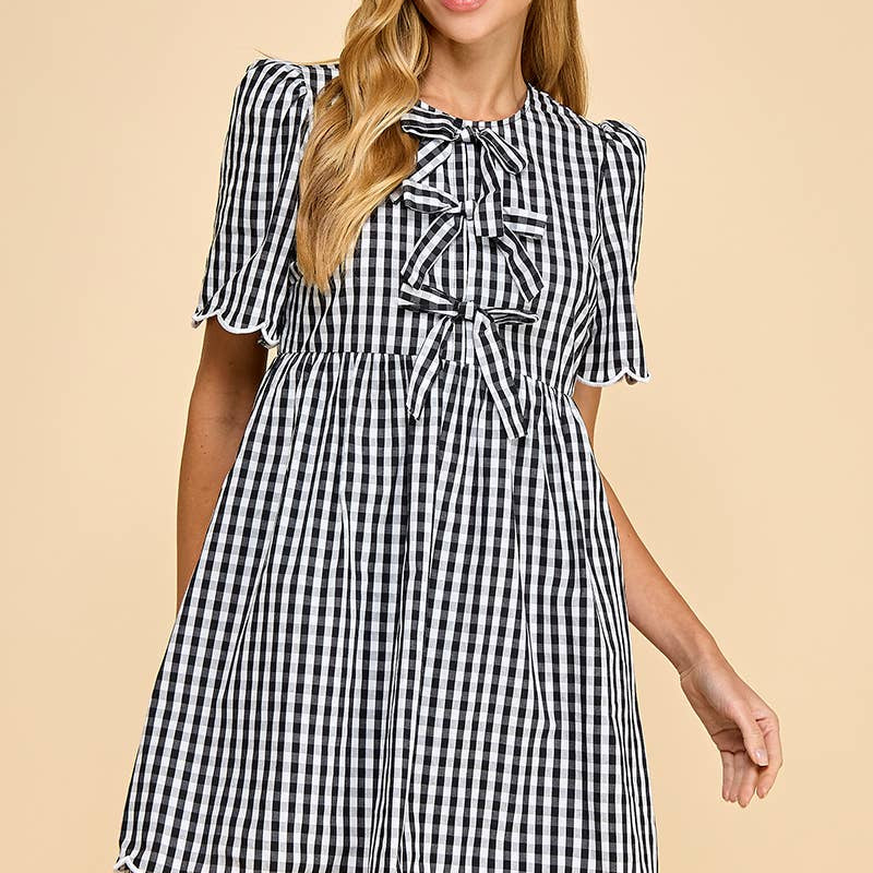 Woman wearing a black and white checkered dress on a beige background