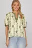 Woman wearing a yellow floral blouse with a blurred background