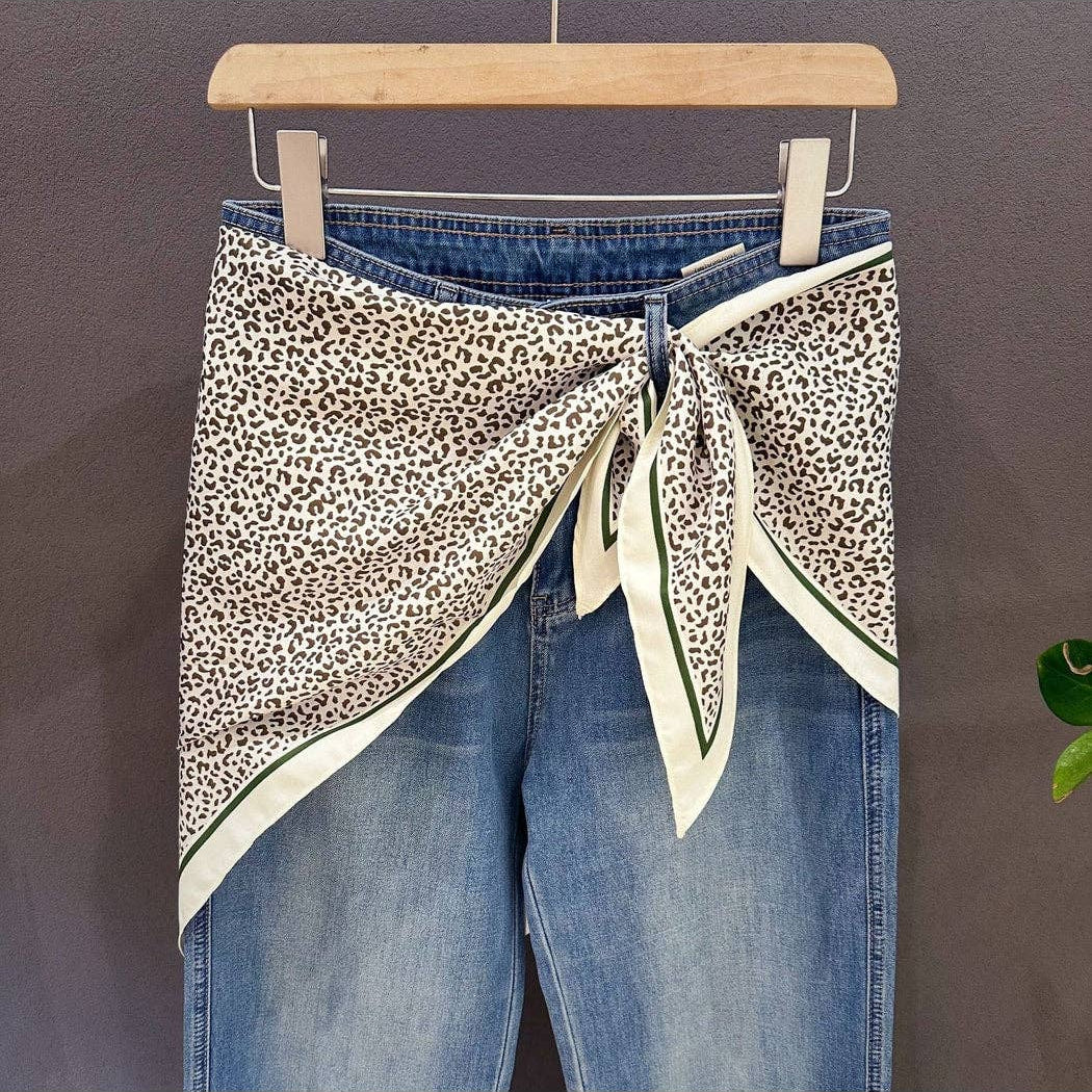 Leopard print triangle bandana with cream ends and green-trimmed borders, knot tied