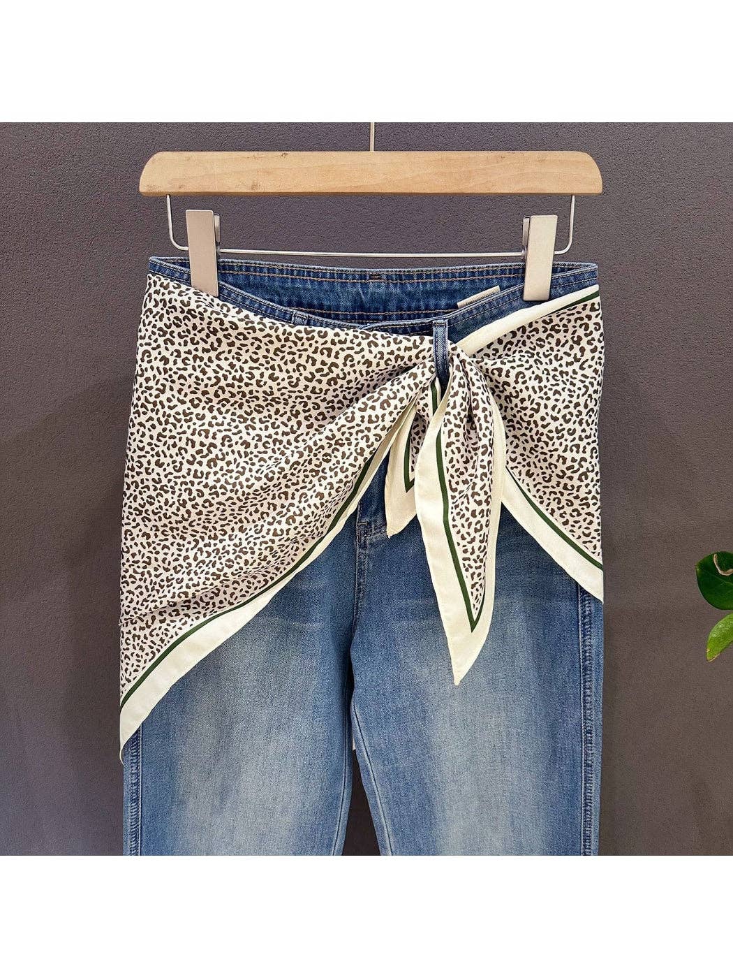 Leopard print triangle bandana with cream ends and green-trimmed borders, knot tied