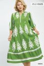 Green dress with white patterns on a model against a white background