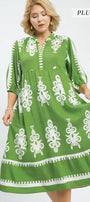 Green dress with white patterns on a model against a white background