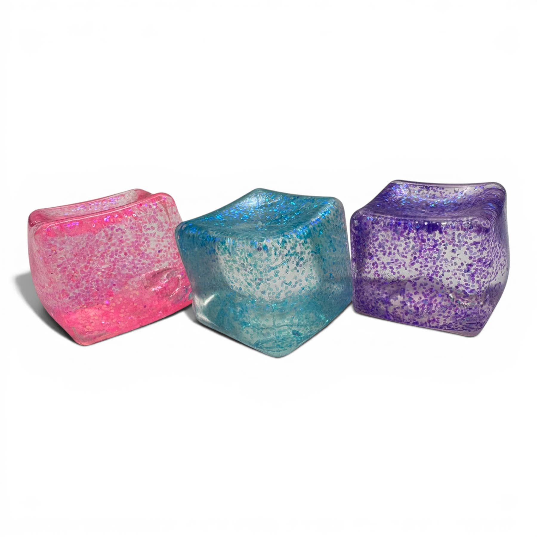 Three colorful glittery cubes on a white background