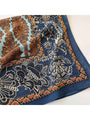 Close-up of navy retro floral square scarf with orange accents and intricate border