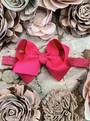 Pink hair bow on a headband surrounded by beige and brown flowers