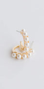 Gold earring with pearls on a light gray background