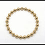 Gold beaded bracelet on a white background