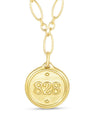 Gold necklace with a round pendant featuring the number 828 on a white background