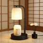Table lamp with a candle and decorative flowers on a wooden surface.