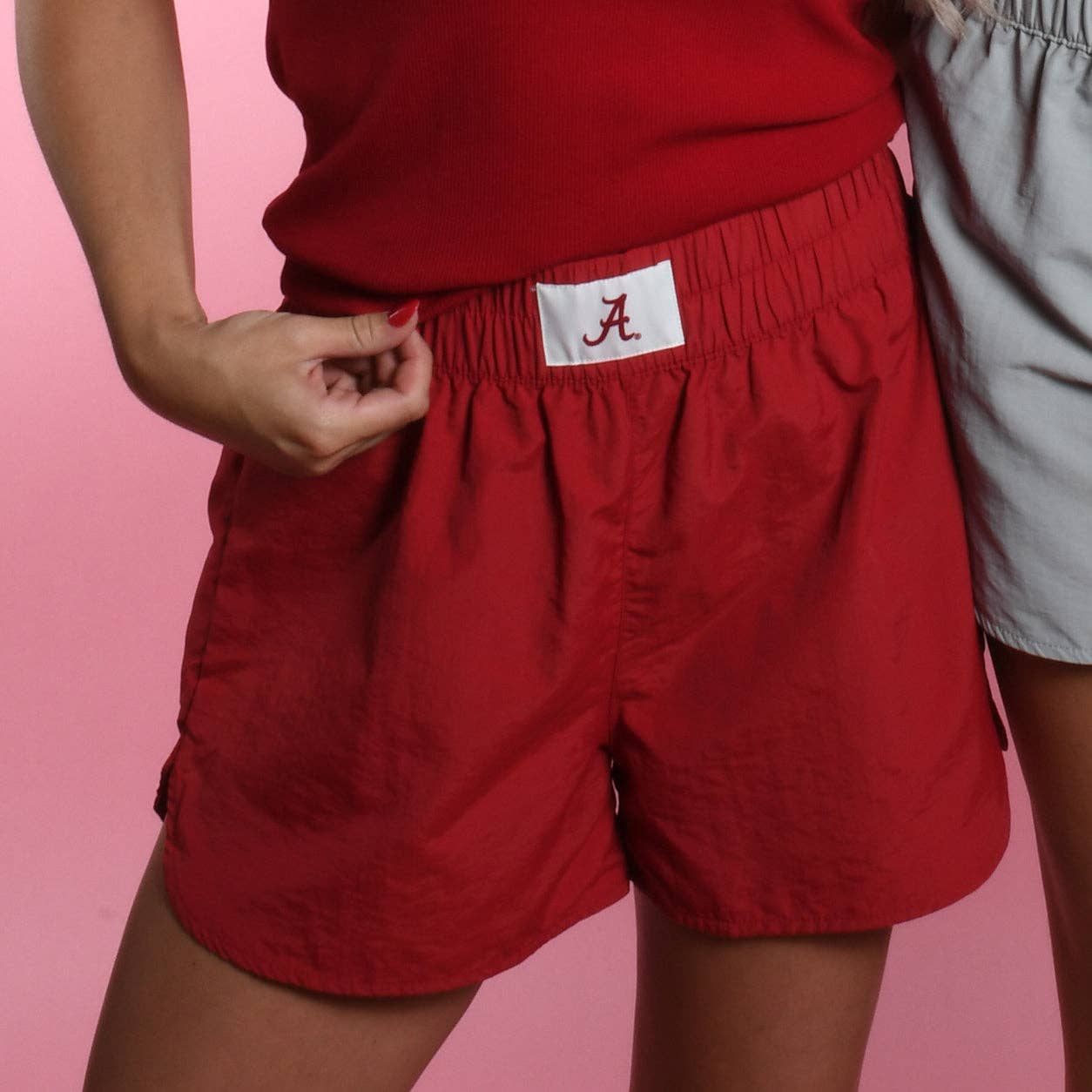 Crimson fabric shorts with elastic waistband and white A patch