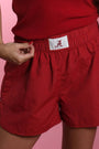 Crimson fabric shorts with elastic waistband and white A patch