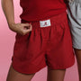 Crimson fabric shorts with elastic waistband and white A patch