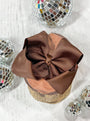 Brown bow on a glittery container with disco balls around