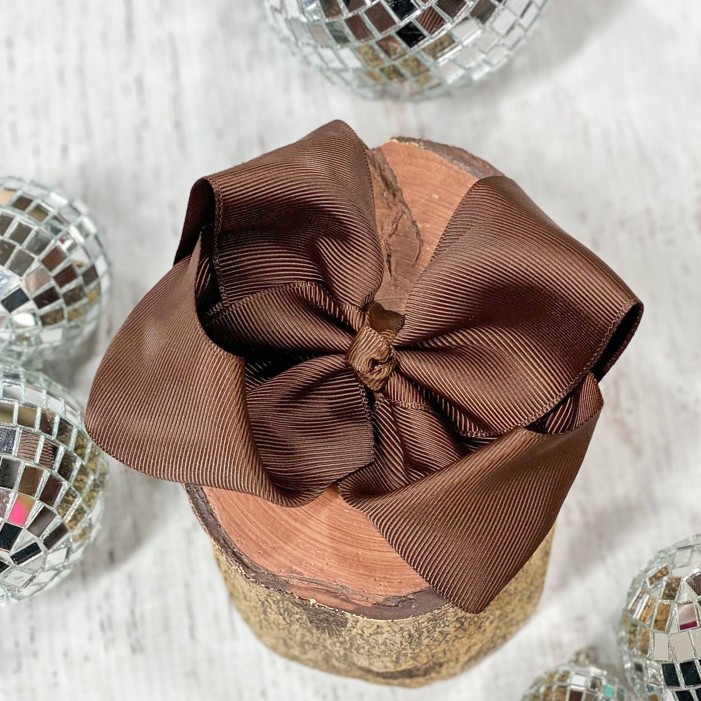 Brown bow on a glittery container with disco balls around