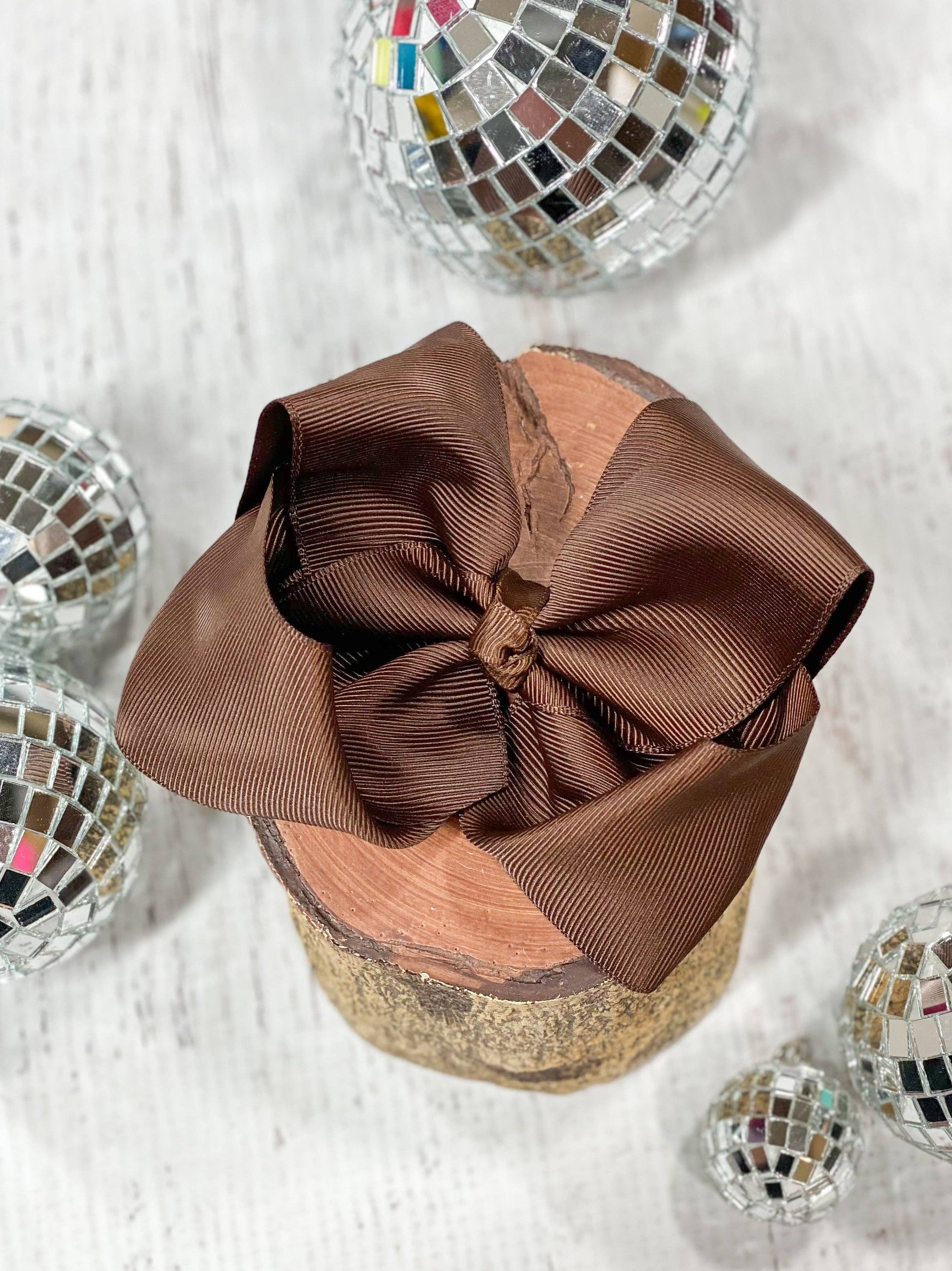 Brown bow on a glittery container with disco balls around