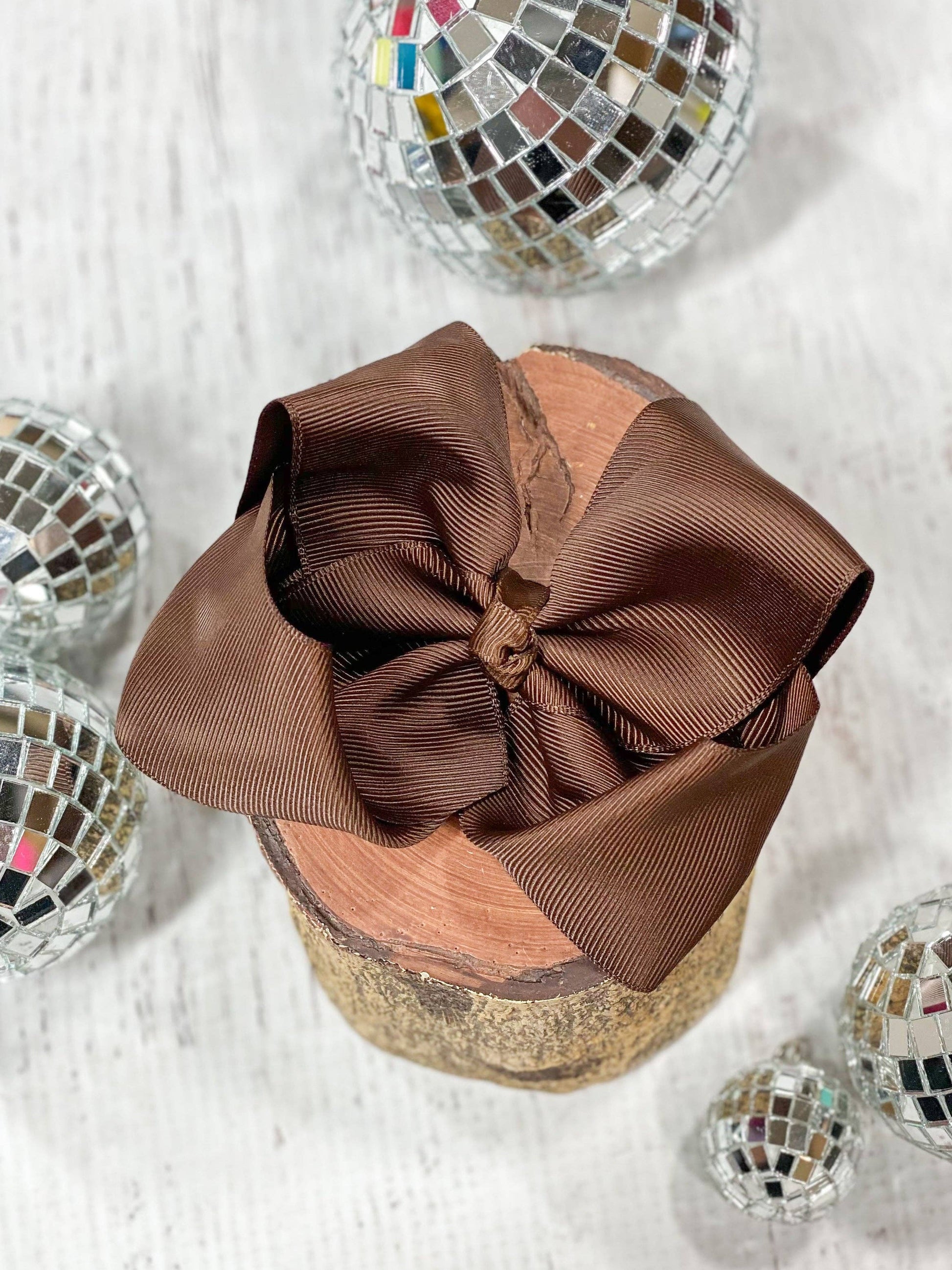 Brown bow on a glittery container with disco balls around