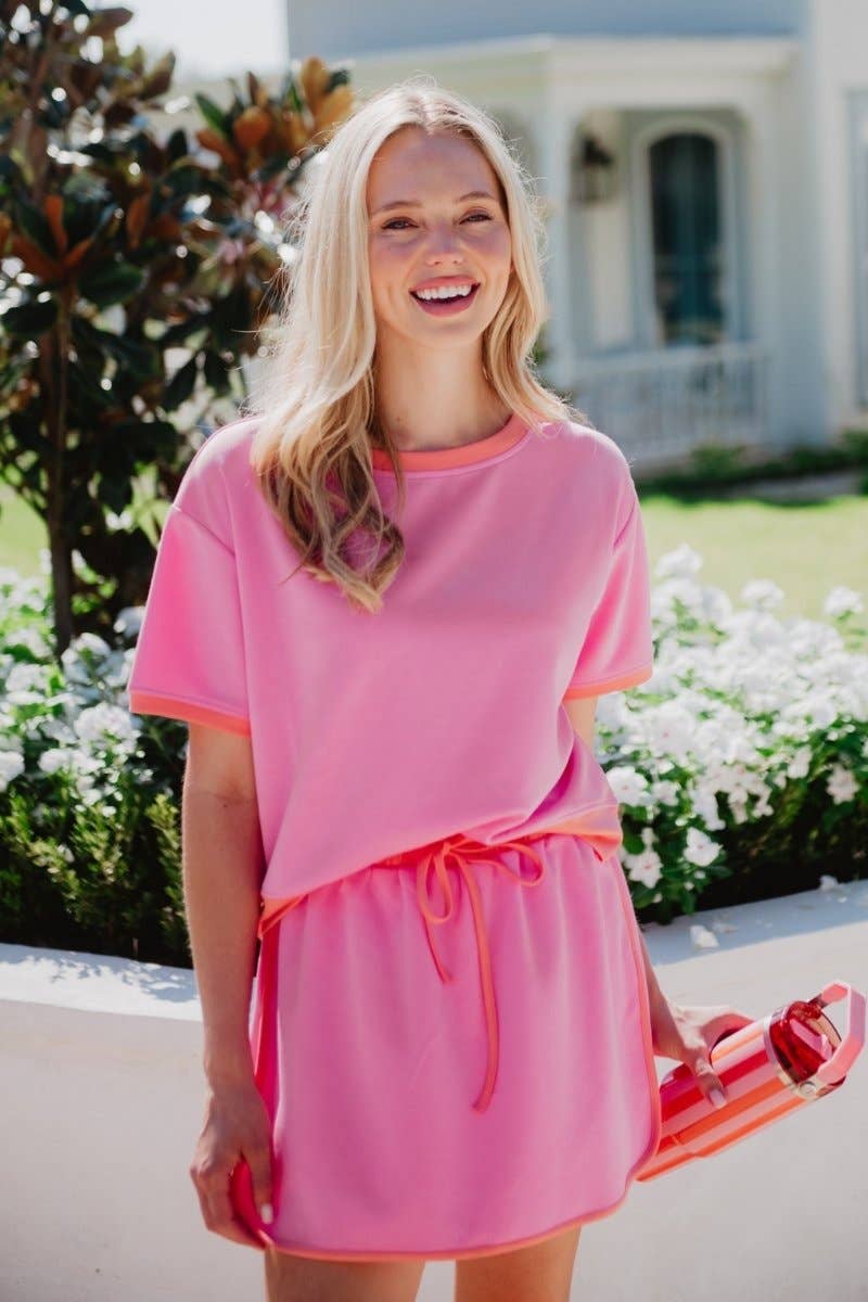 Woman wearing a pink outfit with a blurred background