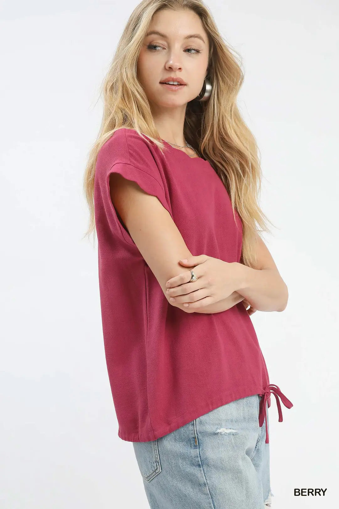Woman wearing a pink t-shirt and light blue jeans on a white background