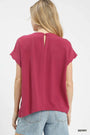 Woman wearing a berry-colored t-shirt on a white background