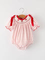 Pink checkered baby romper with red accents on a white background