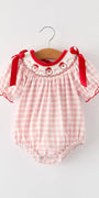 Pink checkered baby romper with red accents on a white background