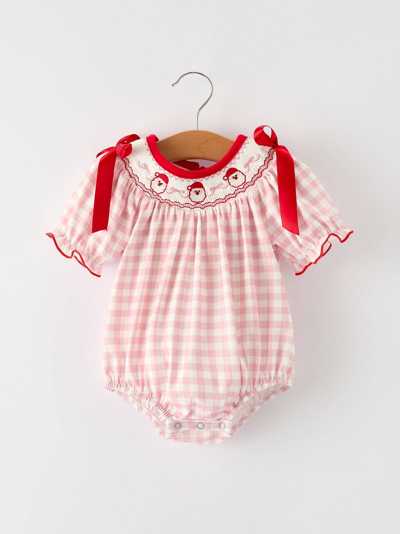 Pink checkered baby romper with red accents on a white background