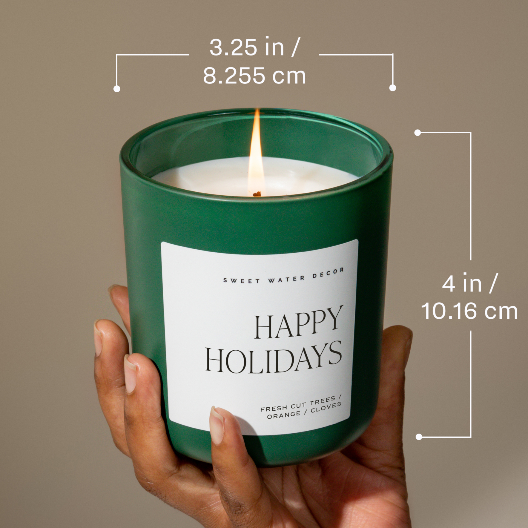 Green candle labeled 'Happy Holidays' held by a hand with measurements displayed.