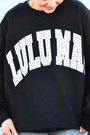 Black sweatshirt with white polka-dot 'WILD' graphic, crew neck and long sleeves