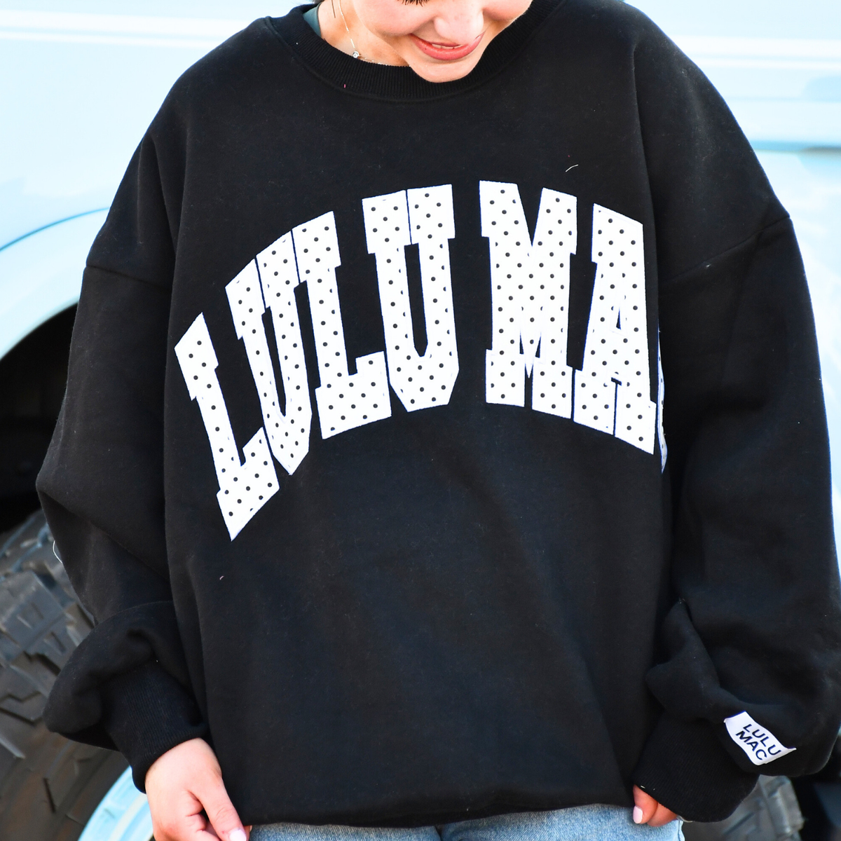 Black sweatshirt with white polka-dot 'WILD' graphic, crew neck and long sleeves