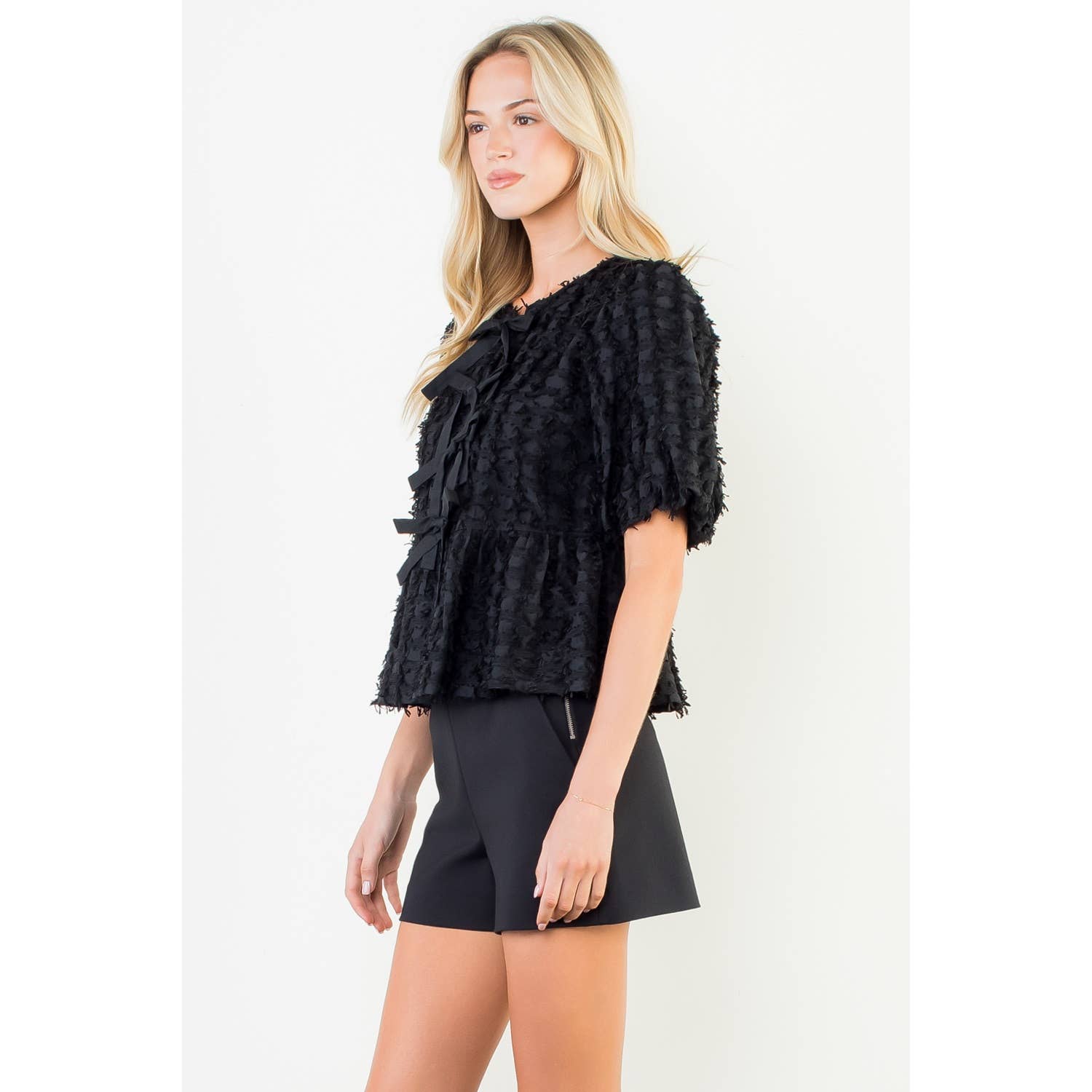Woman wearing a black textured top and skirt on a white background