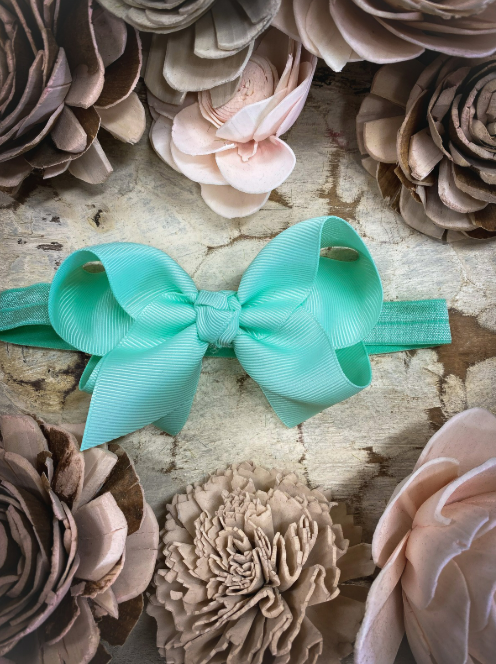 Turquoise bow on a wooden surface with floral decorations