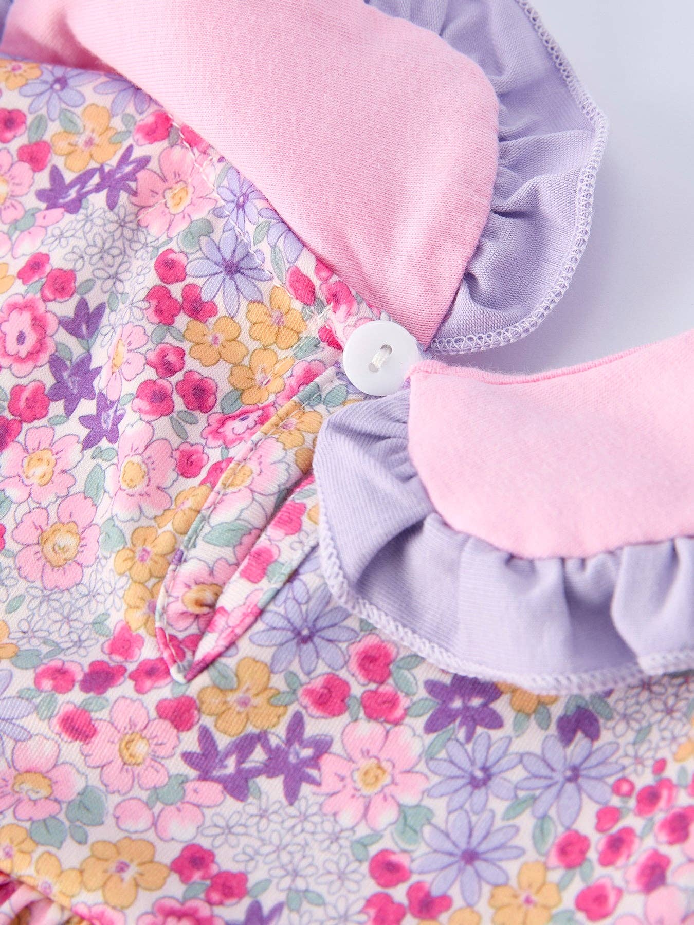 Floral fabric with pink and purple trim on a light background