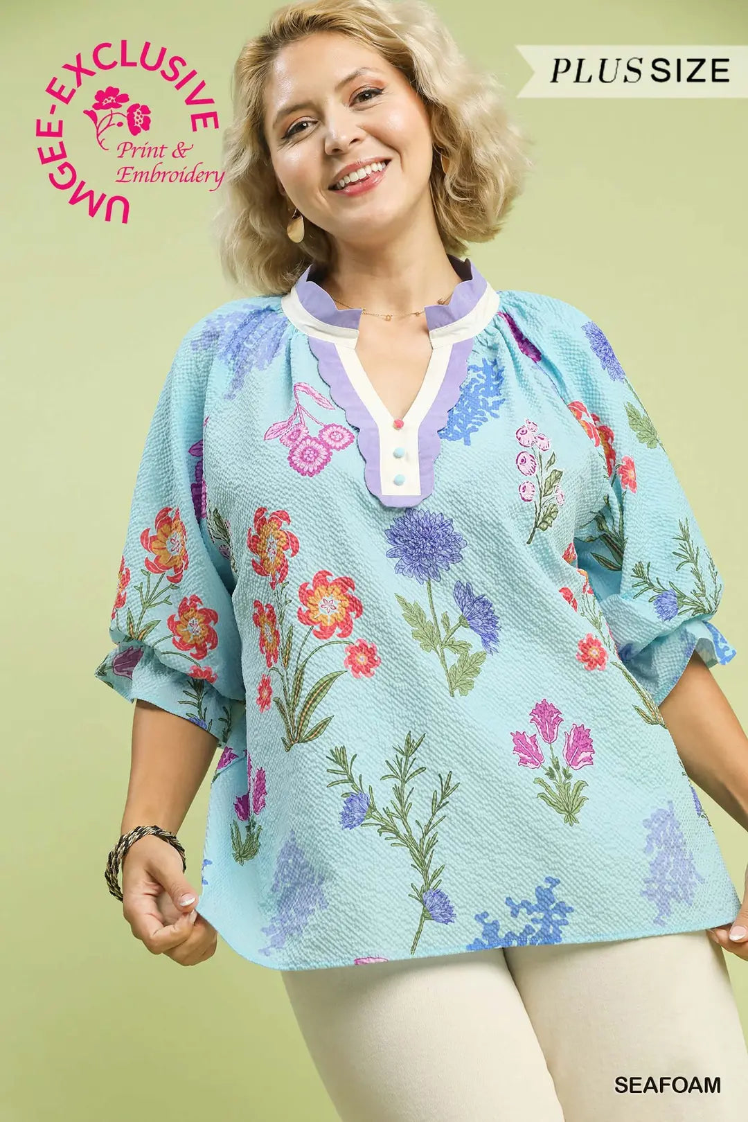 Woman wearing a floral embroidered blouse with a light green background