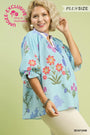 Woman wearing a floral kimono-style top with a green background